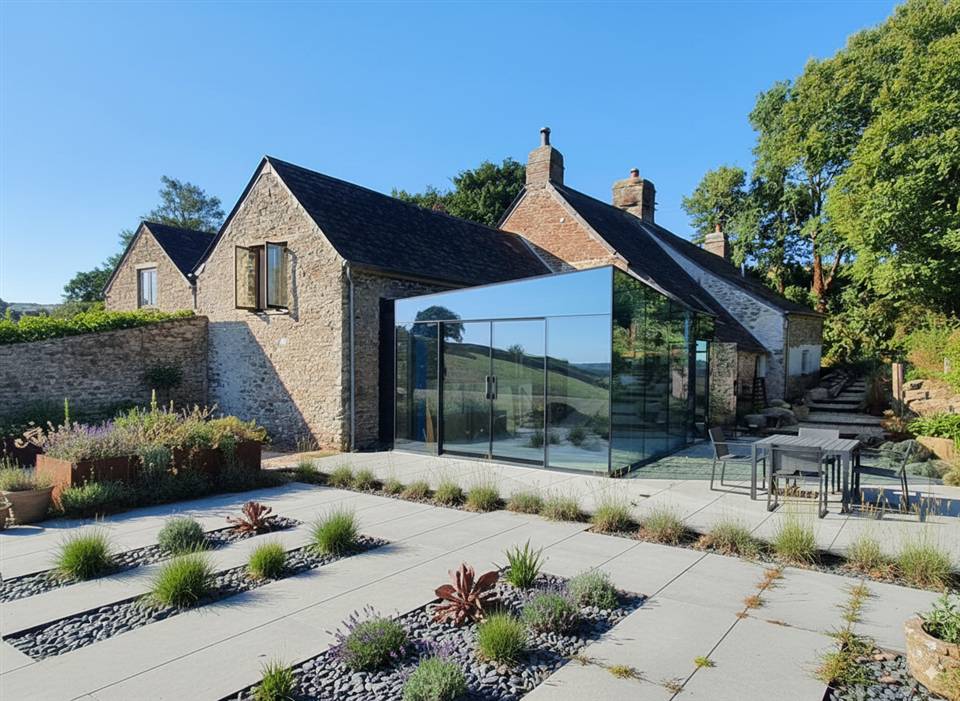 Bespoke contemporary glass extension designed and fitted for a traditional stone farmhouse in Devon